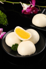 Asian Steamed Buns with Golden Egg Yolk Filling on Black Plate - Traditional Breakfast Pastry