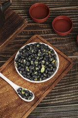 Cooked Black Beans with Green Sprouts in White Bowl on Wooden Cutting Board