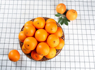 Fresh Navel Oranges in Wicker Basket on White Grid Background - Healthy Citrus Fruit Display