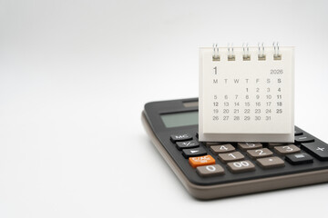 Desk calendar for January 2026 on white background. Calendar concept with 2026 JAN. Calculator and...