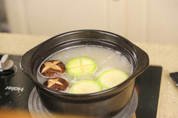 Hot Pot Soup with Beef Meatballs and Cucumber in Black Ceramic Bowl - Traditional Asian Comfort Food