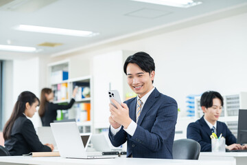 Fototapeta premium オフィスで働く若いビジネスマン