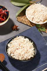 Dried Shrimp in Bowl with Asian Spices and Cooking Ingredients on Dark Wood Surface