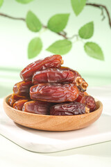 Fresh Medjool Dates in Wooden Bowl - Traditional Middle Eastern Dried Fruit with Natural Green Background