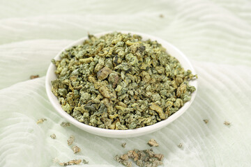 Dried Green Tea Leaves Granules in White Bowl - Herbal Wellness Beverage Concept
