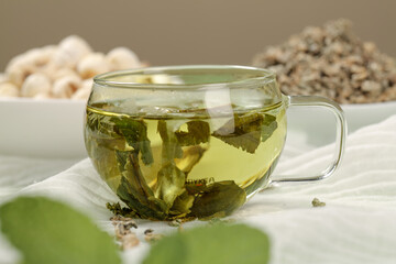 Fragrant Lotus Leaf Tea in Glass Cup with Dried Herbal Pellets and Summer Wellness Setup