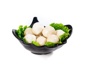 Hot beef meatballs in black pot with lettuce garnish - Asian cuisine delicacies and ingredients variety