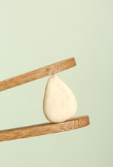 Peeled Almond Balanced in Wooden Tongs - Natural Food Photography with Minimalist Styling