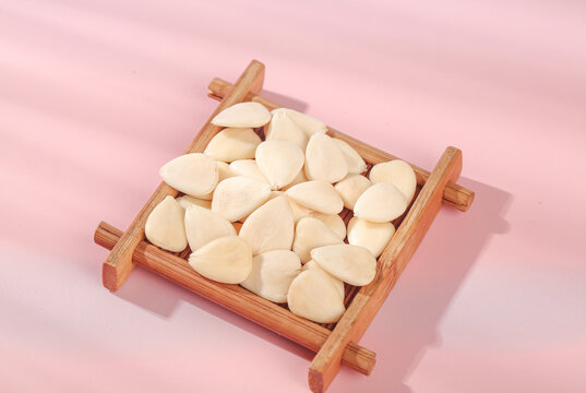 Peeled Sweet Almonds Sliced in Wooden Tray on Pink Background - Healthy Nut Showcase - Powered by Adobe
