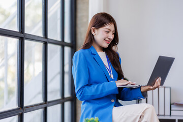 Attractive asian woman, Manager with laptop stands in office area of coworking space
