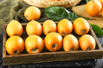 Fresh Loquat Fruits in Wooden Box - Panzhihua Mountain Harvest Display with Green Leaves