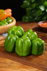 Fresh Green Bell Peppers on Wooden Cutting Board with Colorful Vegetables for Healthy Cooking