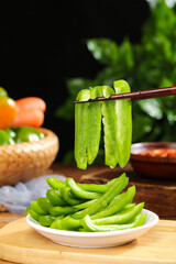 Fresh Green Bell Pepper Slices with Chopsticks on Kitchen Cutting Board