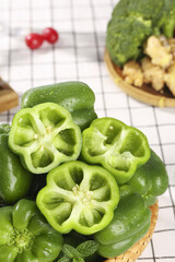 Fresh Green Bell Peppers with Colorful Lantern-Shaped Interior Features in Wicker Basket