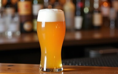 A glass of beer sits atop a bar, ready to be enjoyed. High quality