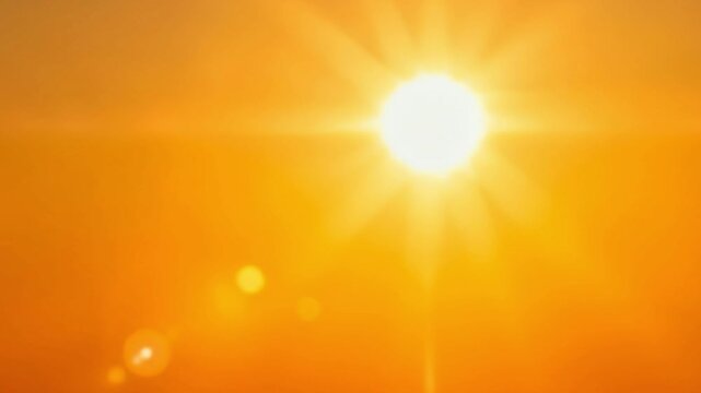 The video depicts an abstract, intensely bright light source, reminiscent of a blazing sun, radiating warmth and energy across an vibrant orange and yellow gradient background. Dynamic lens flares and