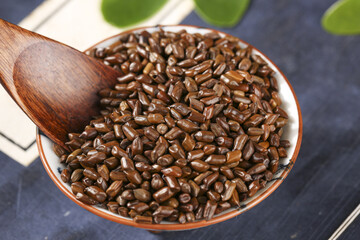 Chinese Cassia Seeds in Bowl with Wooden Spoon for Traditional Herbal Tea Making