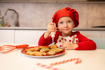 Young child decorating cookies in a cozy kitchen during the holiday season with bright colors and festive decorations