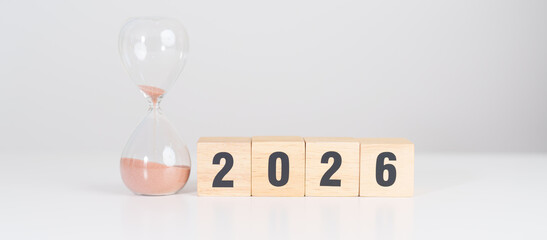 Happy New Year 2026 with hourglass on table. Resolution, time, plan, goal, motivation, reboot, countdown and New Year holiday concepts