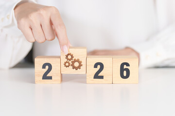 2026 year block with gear icon. Business Process, Team, teamwork, Goal, Target, Resolution, strategy, plan, Action, motivation, change, brainstorm and New Year start concepts