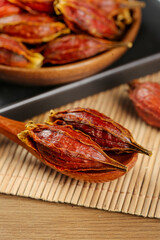 Dried Sichuan Gardenia Fruit on Bamboo Mat - Traditional Chinese Medicinal Herbs and Spices Display