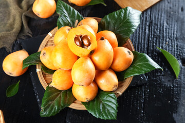 Fresh Loquat Fruits from Sichuan Mountains in Bamboo Basket with Leaves