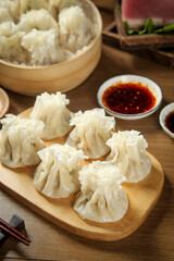 Handmade Mongolian Shumai Dumplings with Chili Sauce on Wooden Serving Board - Traditional Asian Cuisine
