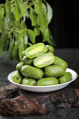 Fresh Dandong Kiwi Berries Rich in Vitamins on Rustic Wood Surface with Natural Green Background