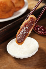 Handmade Deep Fried Sweet Pastry with Red Bean Filling and Sugar Crystals Held by Chopsticks