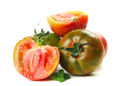 Fresh Heirloom Tomatoes Sliced with Basil Leaves on White Background - Powered by Adobe