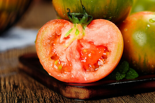 Fresh Dandong Tomatoes Cut in Half on Wooden Board Showing Juicy Interior with Seeds