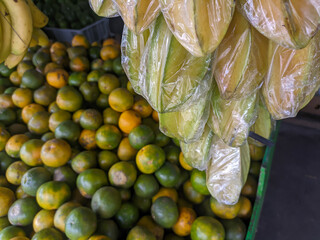 The grocery store offers a variety of delicious fresh fruits. Star fruit and oranges are on display.