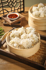 Traditional Chinese Dim Sum Dumplings in Bamboo Steamer Baskets with Spicy Sauce Asian Cuisine