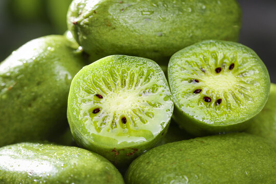 Fresh Kiwi Berry Fruits Cut in Half Showing Green Flesh and Seeds - Healthy Vitamin Rich Small Exotic Fruit