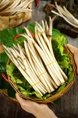 Freshly Dug Lotus Root Vegetables in Wicker Basket with Green Leaves