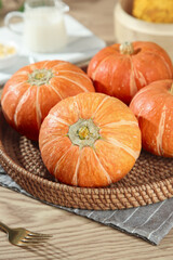Fresh Orange Pumpkins in Wicker Basket - Autumn Harvest Home Decor on Rustic Wood Table
