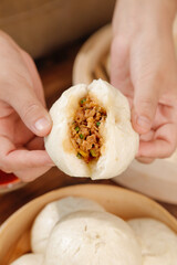 Handmade Steamed Bun with Fresh Meat and Scallion Filling Held in Hands