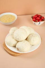 Fresh Handmade Pork Buns with Dipping Sauce and Cherry Tomatoes on Wooden Board
