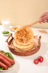 Traditional Handmade Scallion Pancakes Chinese Breakfast Food in Wicker Basket with Wooden Tongs