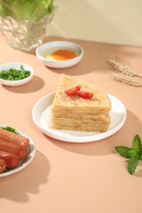 Handmade Layered Puff Pastry Square with Red Pepper Garnish and Fresh Herbs Food Photography