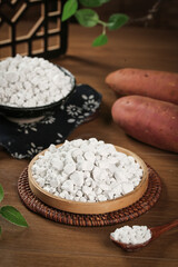 Sweet Potato Starch Powder in Wooden Bowls with Fresh Potatoes on Rustic Kitchen Table