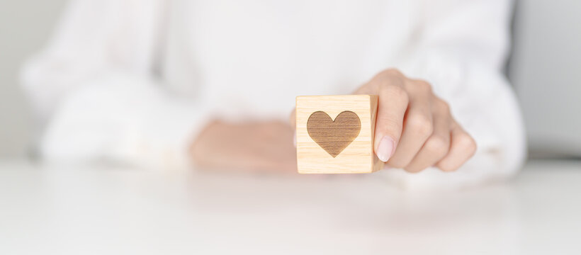 Hand holding heart block for health care, love, organ donation, charity, happy family, wellbeing and insurance concepts. world heart day, health day and mental health day