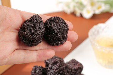 Dried Candied Plum Fruits in Hand - Traditional Asian Preserved Snack