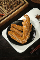 Baked marinated duck wings with soy sauce glaze and five spice seasoning on rustic wooden table