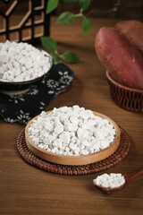 Raw Potato Starch Granules in Handmade Wicker Baskets on Wooden Table - Natural Food Ingredient