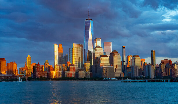 New York City with dark sky. New York City skyline with dramatic clouds. Manhattan skyscrapers in golden night at New York City. Iconic cityscape of lower Manhattan in New York City. NY view. - Powered by Adobe