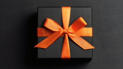 Elegant Black Gift Box with Vibrant Orange Bow on Dark Surface