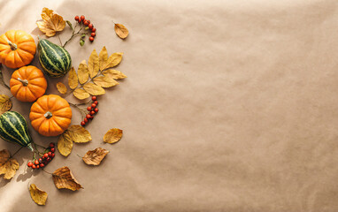 Autumn Pumpkins, Gourds, and Fall Leaves on Kraft Paper Background with Copy Space