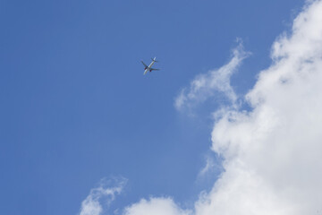 Military fighter jet flying high in blue sky with white clouds. This powerful aircraft soaring through air creates feeling of freedom, speed, and travel