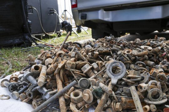 Chaotic pile of old, rusty scrap metal hardware. Large, dirty collection of junk with various assorted bolt, nut, screw and washer parts for salvage and recycling work